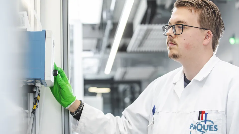 Medewerker van Paques drukt op scherm van installatie