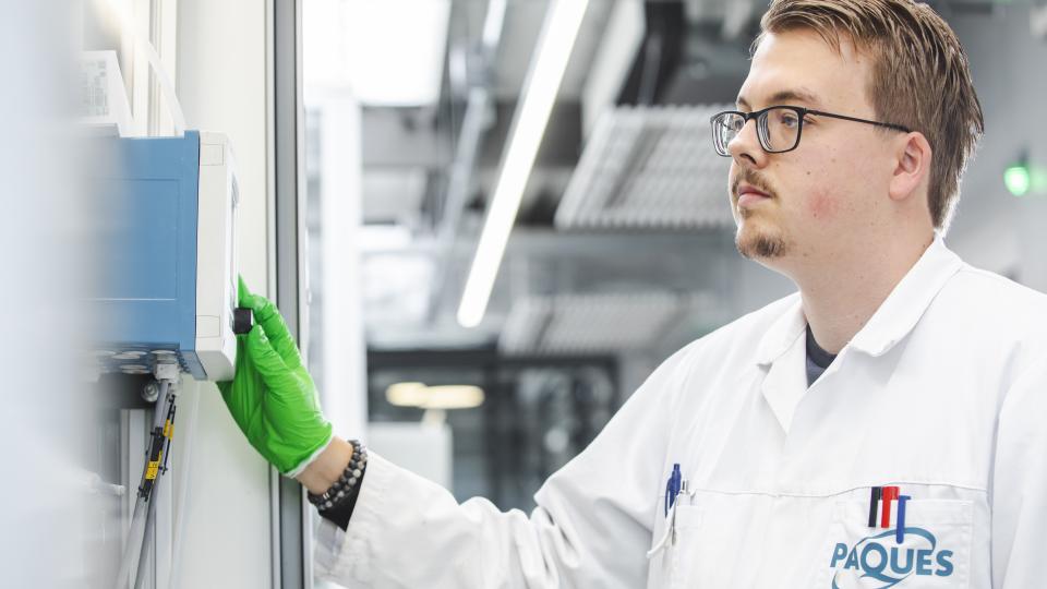 Medewerker van Paques drukt op scherm van installatie