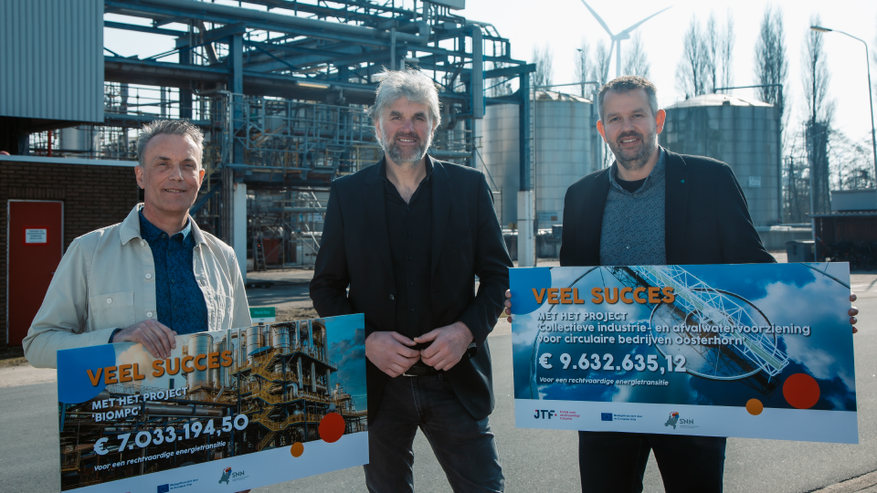 3 mannen. 2 met een cheque in de handen van een subsidieoverhandiging namens de gedeputeerde