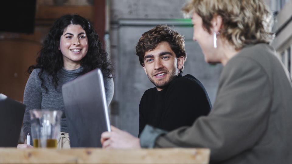 Mensen aan een tafel de ideeën uitwisselen