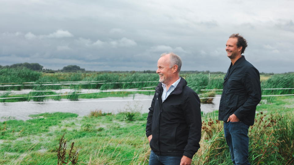 twee ondernemers poserend in een weiland