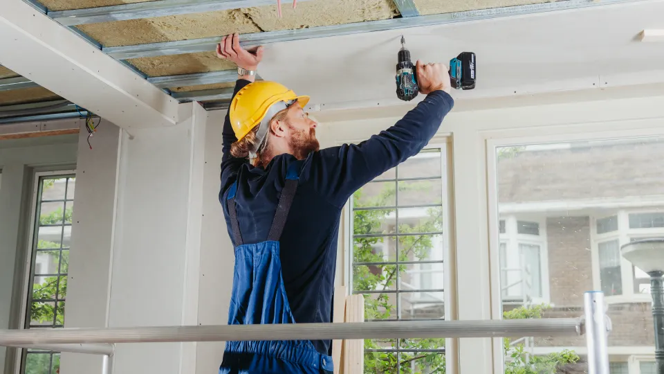 Man isoleert plafond huis