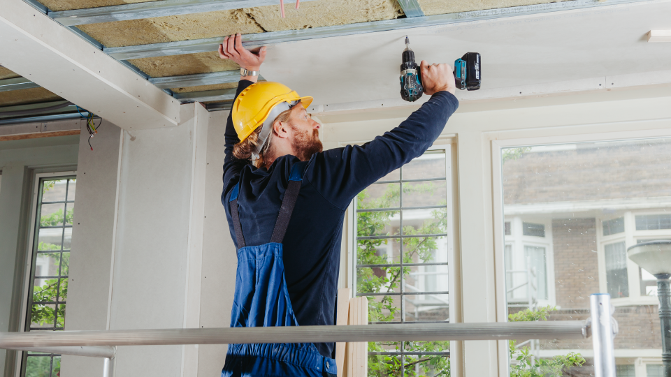 Man isoleert plafond huis