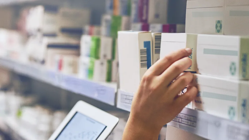 Apotheker pakt medicatie uit schap