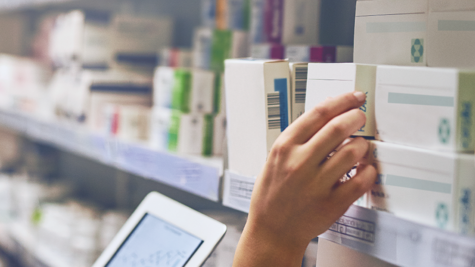 Apotheker pakt medicatie uit schap