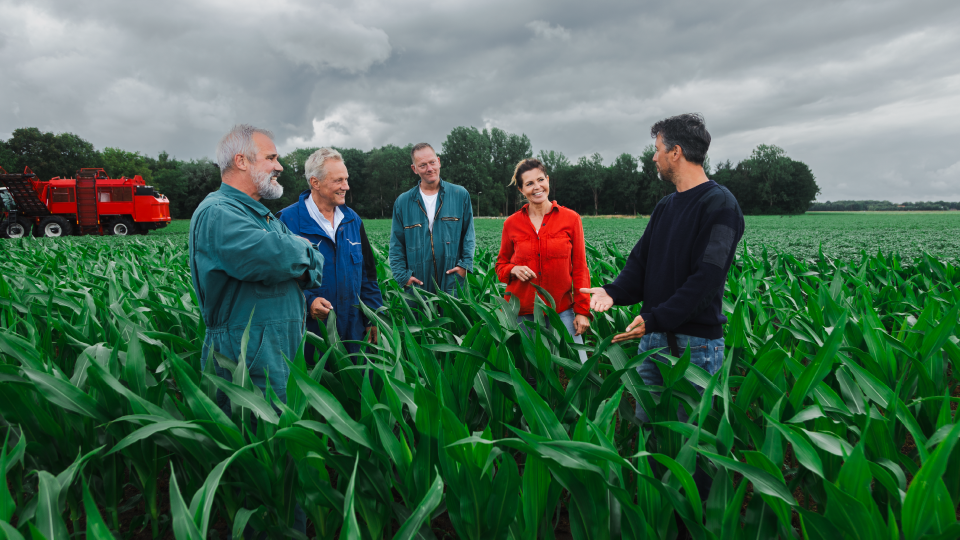 5 boeren pratend in een boerenlandschap