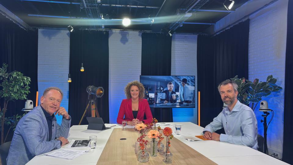 Foto van gastvrouw en twee sprekers aan tafel tijdens het webinar
