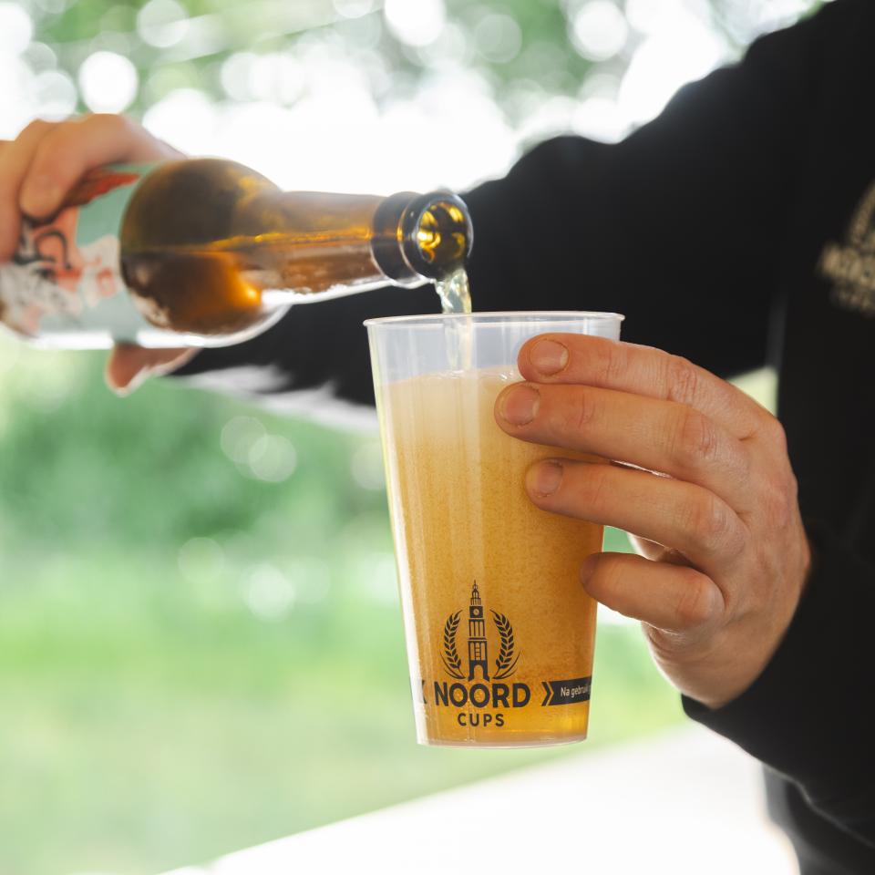 Bierflesje wordt in Noord Cups beker geschonken