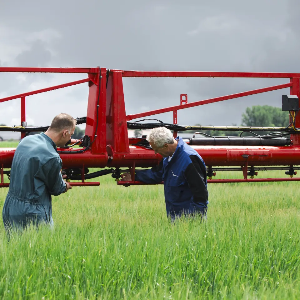 Mannen bij machine op het land