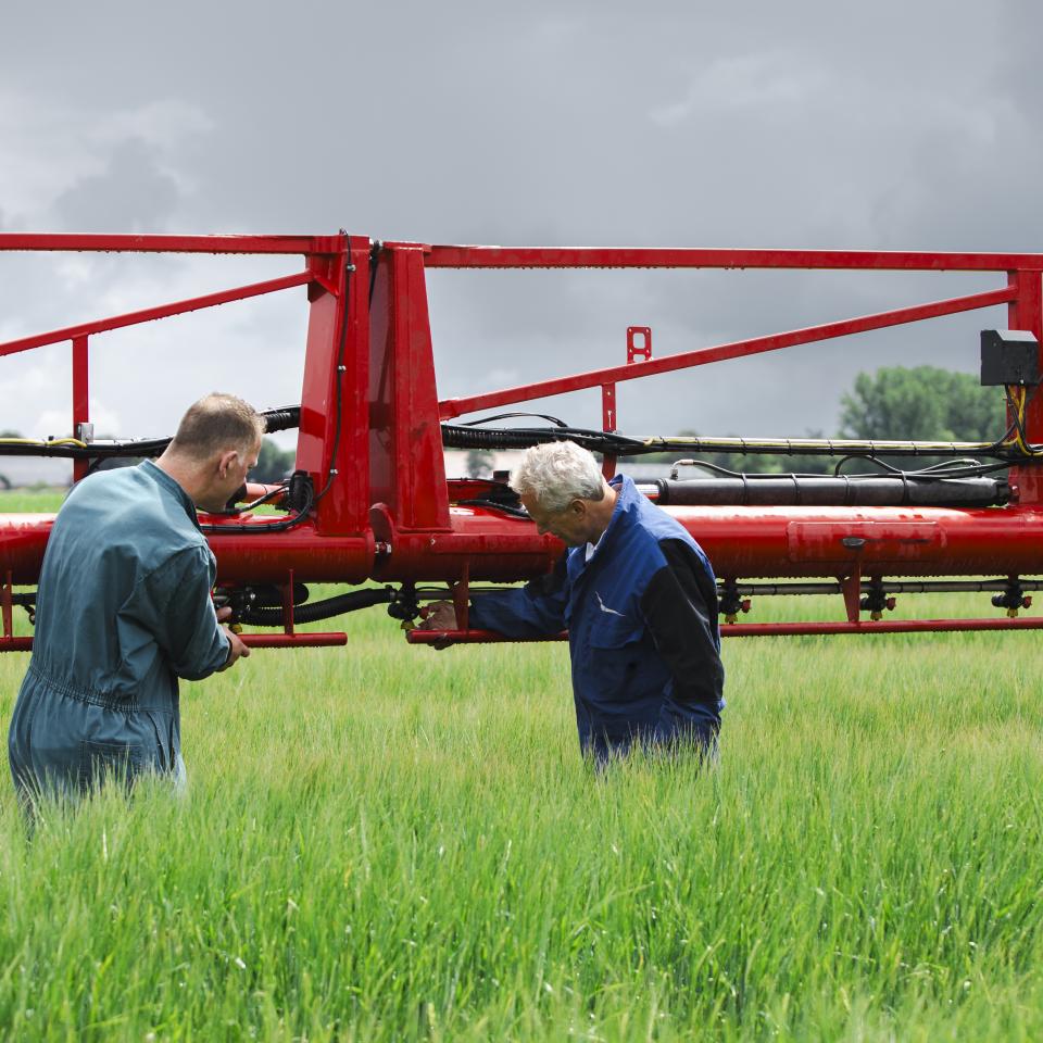 Mannen bij machine op het land